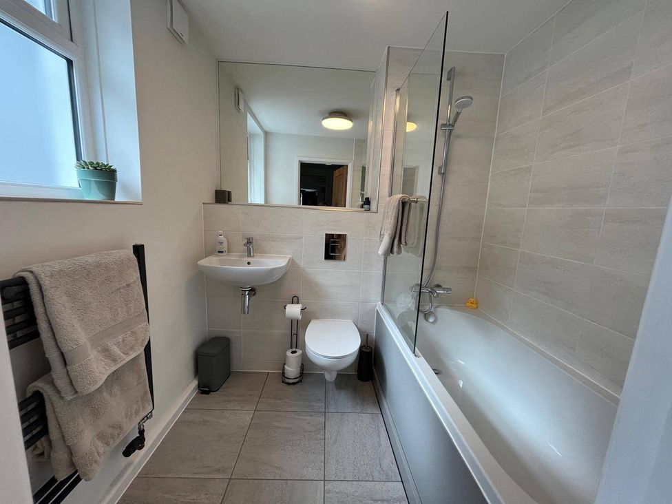 A bathroom with a shower, bathtub, sink, and toilet at Charming 3Bed Cottage  Private Garden Parking in Torquay
