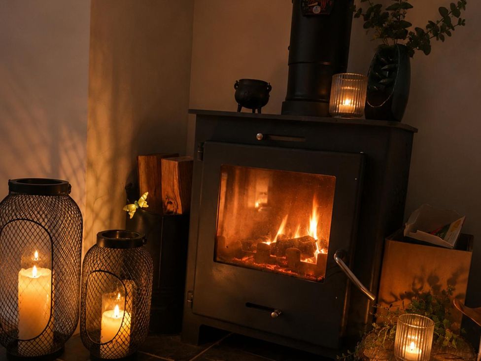A living room with a stove and candles at 3Bed House Sleeps 7 Parking Garden Pets Ok in Lytham St. Annes