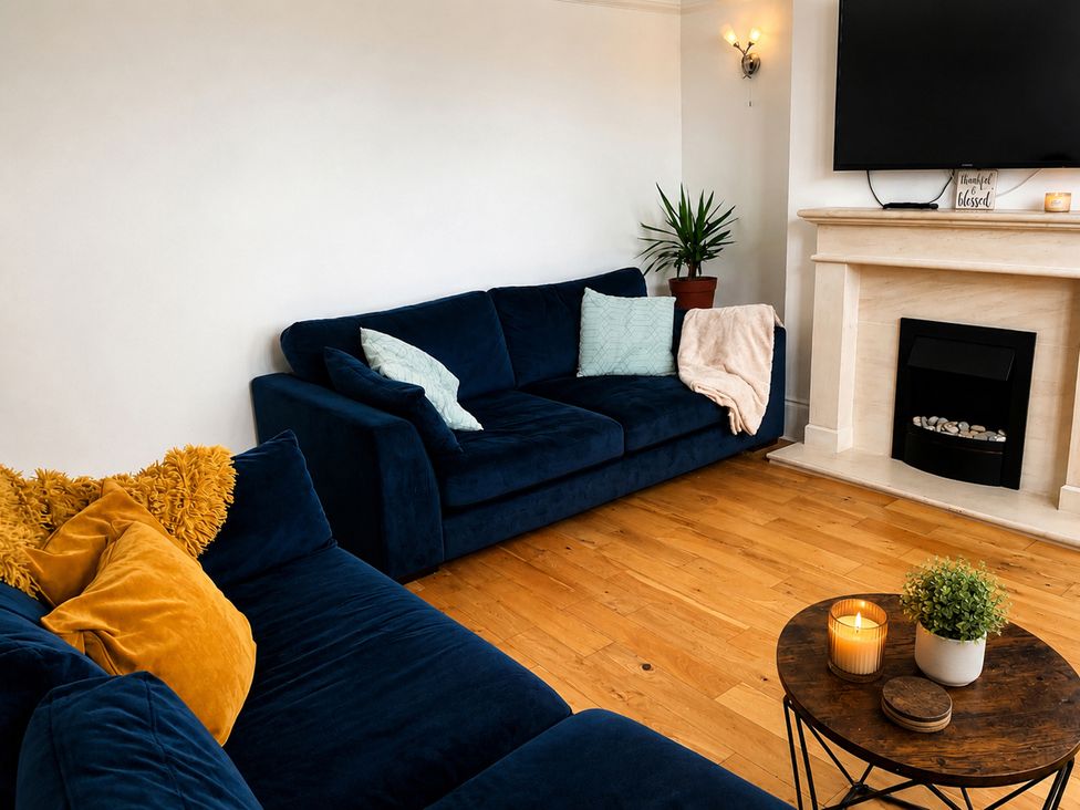 A living room with a sofa and television at 3Bed House Sleeps 7 Parking Garden Pets Ok in Lytham St. Annes