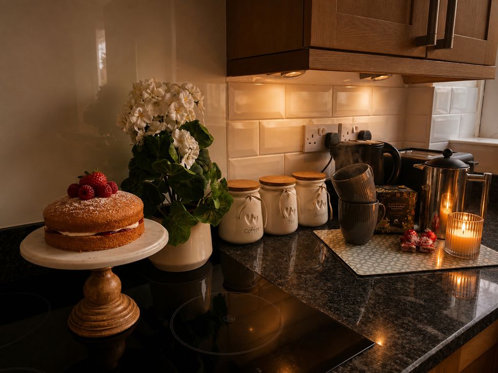 A kitchen with a cake and flowers on the countertop at 3Bed House Sleeps 7 Parking Garden Pets Ok Lytham St. Annes