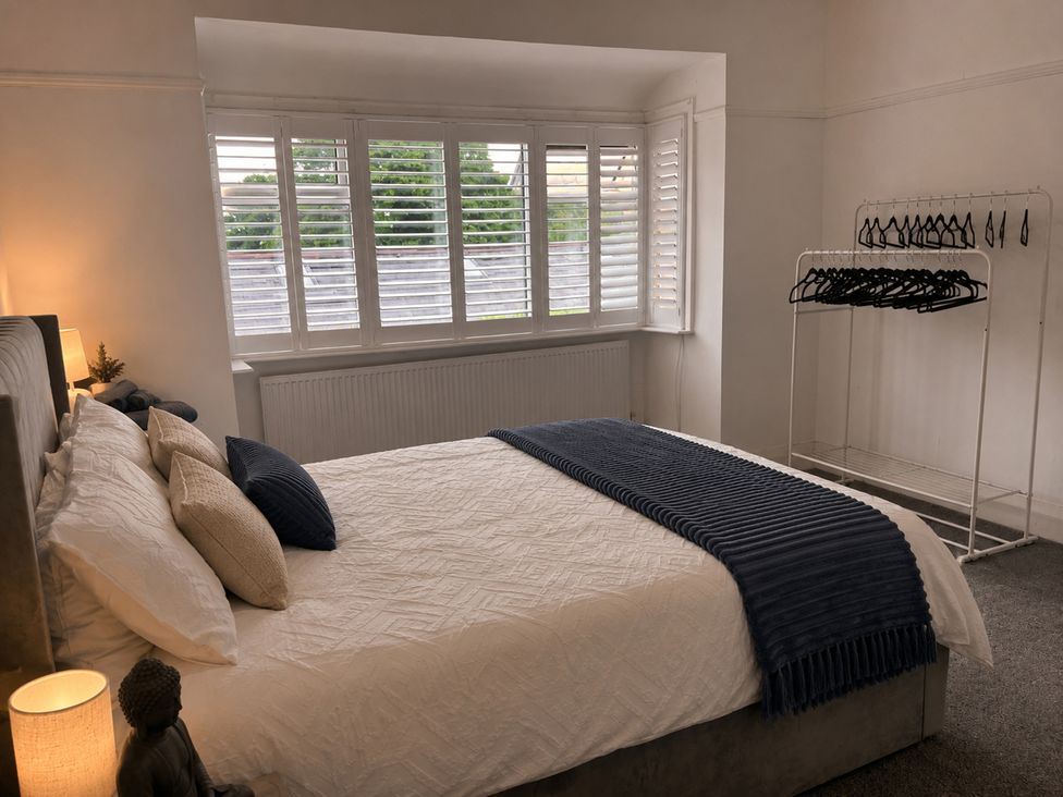 A bedroom with a bed and coat rack at 3Bed House Sleeps 7 Parking Garden Pets Ok Lytham St. Annes