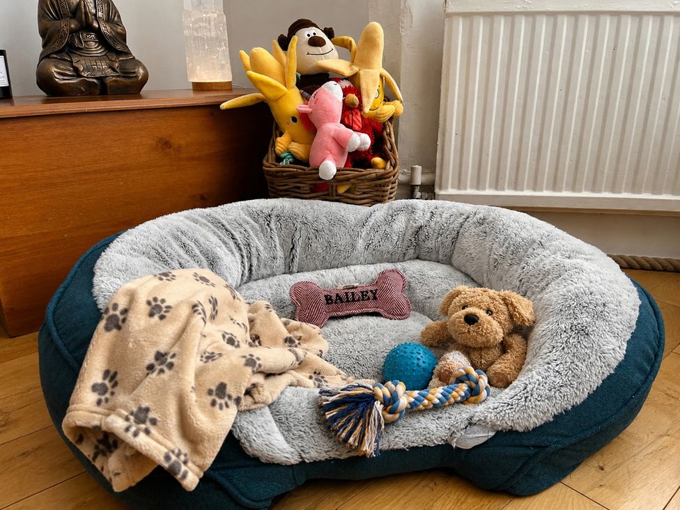 A dog bed with toys and a blanket at 3Bed House Sleeps 7 Parking Garden Pets Ok Lytham St. Annes