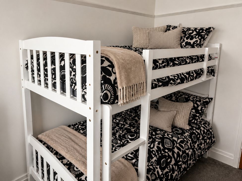 Bunk bed with patterned bedding and pillows at 3Bed House Sleeps 7 Parking Garden Pets Ok Lytham St. Annes