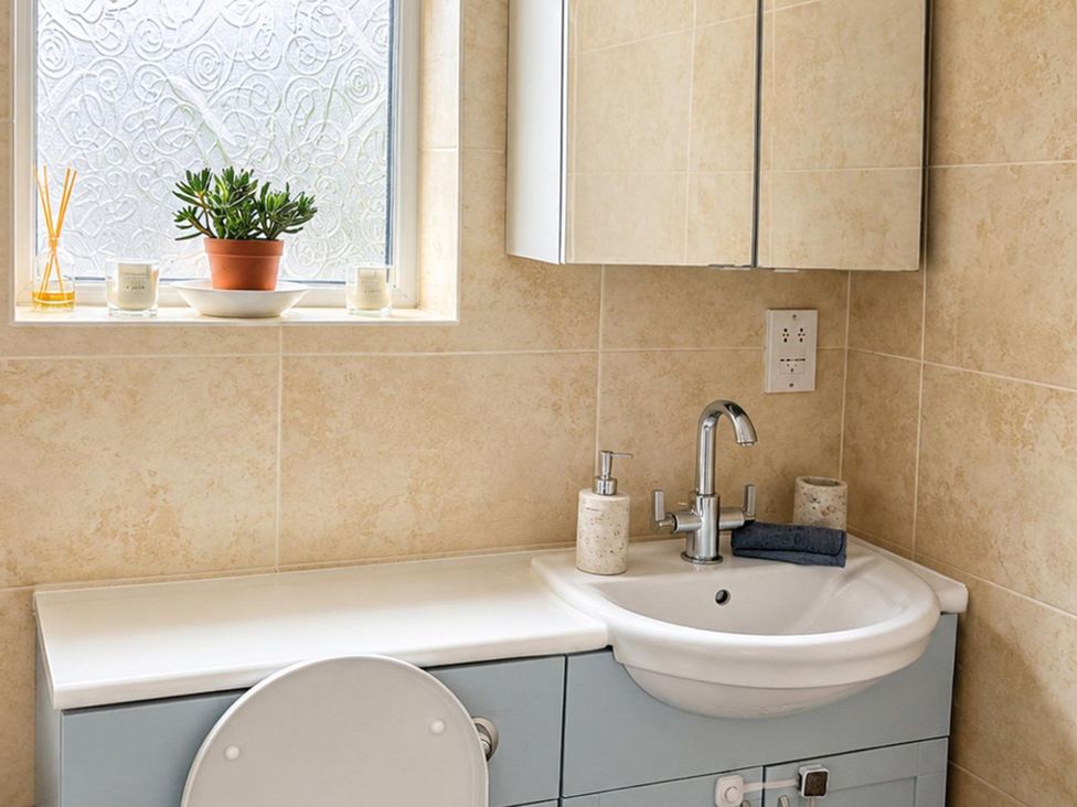 A bathroom with a sink and storage cabinet at 3Bed House Sleeps 7 Parking Garden Pets Ok in Lytham St. Annes