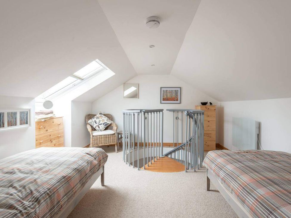 A bedroom with two beds and a staircase at 2bed Cottage Private garden Freeparking in Aviemore
