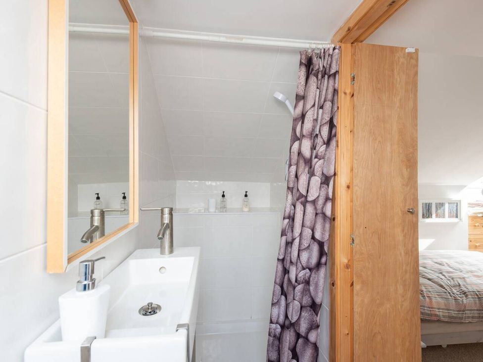 A bathroom with a sink and mirror at 2bed Cottage Private garden Freeparking in Aviemore