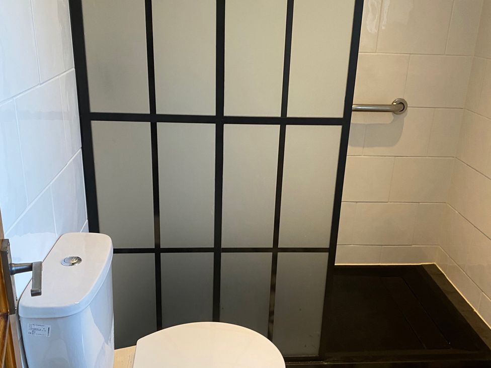 A bathroom with a toilet and shower stall at 2bed Cottage Private garden Freeparking in Aviemore