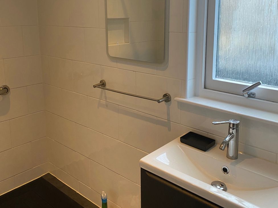 A bathroom with a sink and mirror at 2bed Cottage Private garden Freeparking in Aviemore