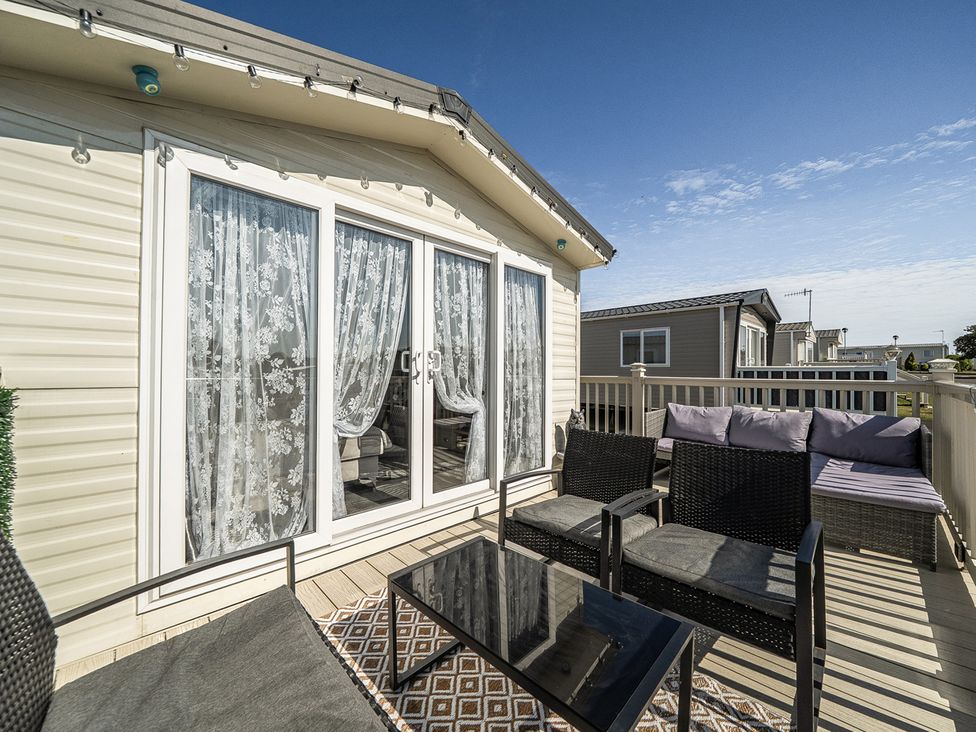 An outdoor terrace with seating and table at Cayton Bay Holiday Park Kestrel40