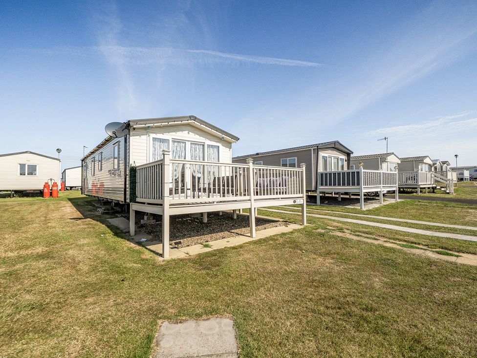 A caravan with a deck in a holiday park at Cayton Bay Holiday Park Kestrel40, Cayton Bay