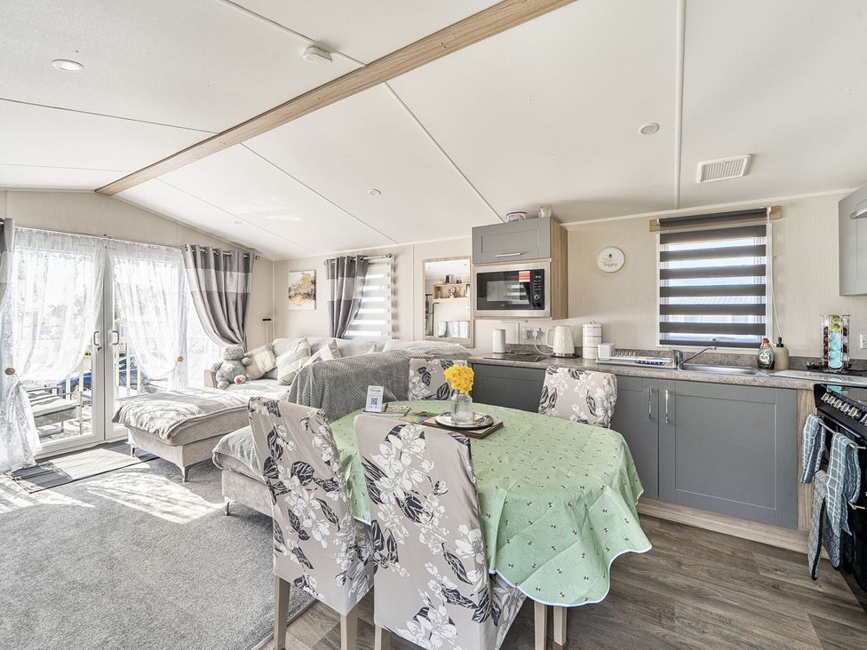 A kitchen with a table and chairs at Cayton Bay Holiday Park Kestrel40 in Cayton Bay