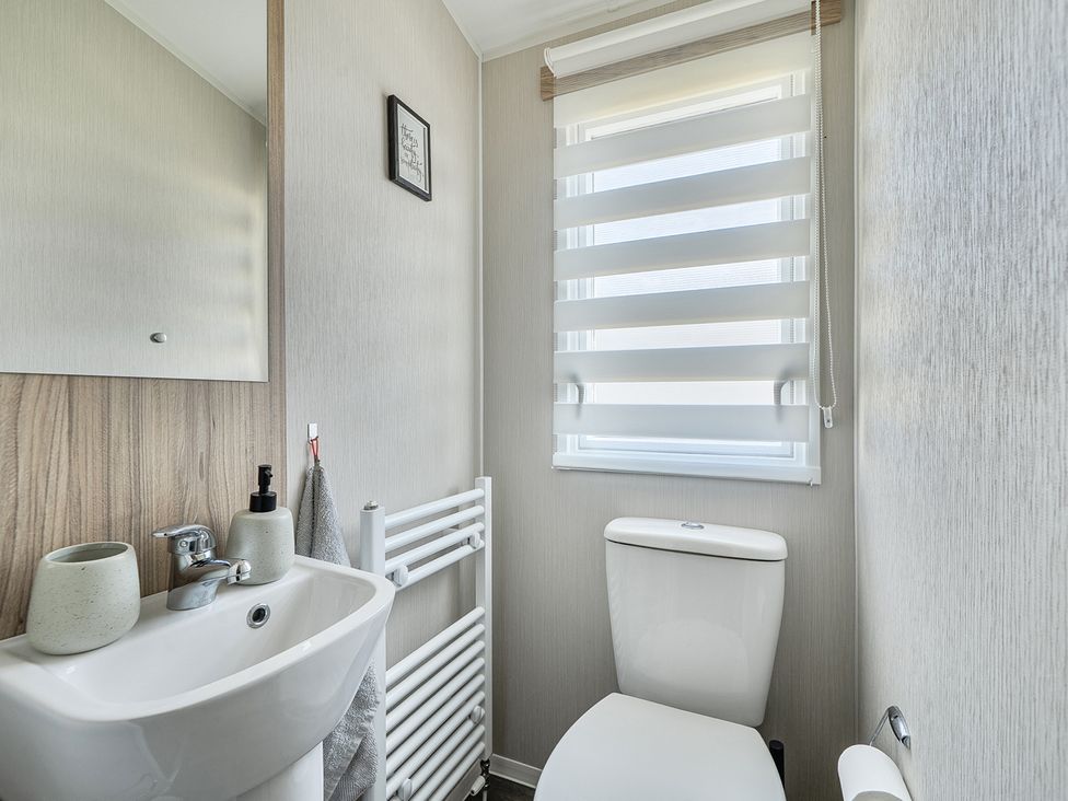 A bathroom with a sink and toilet at Cayton Bay Holiday Park Kestrel40 in Cayton Bay