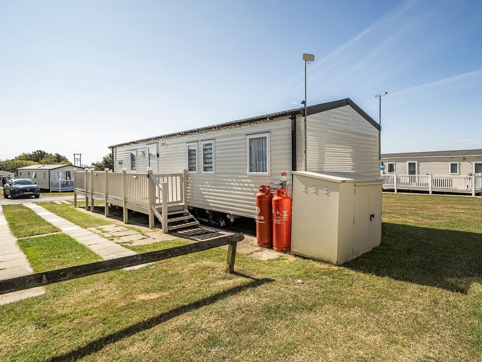A caravan with decking and gas cylinders at Cayton Bay Holiday Park Kestrel40, Cayton Bay