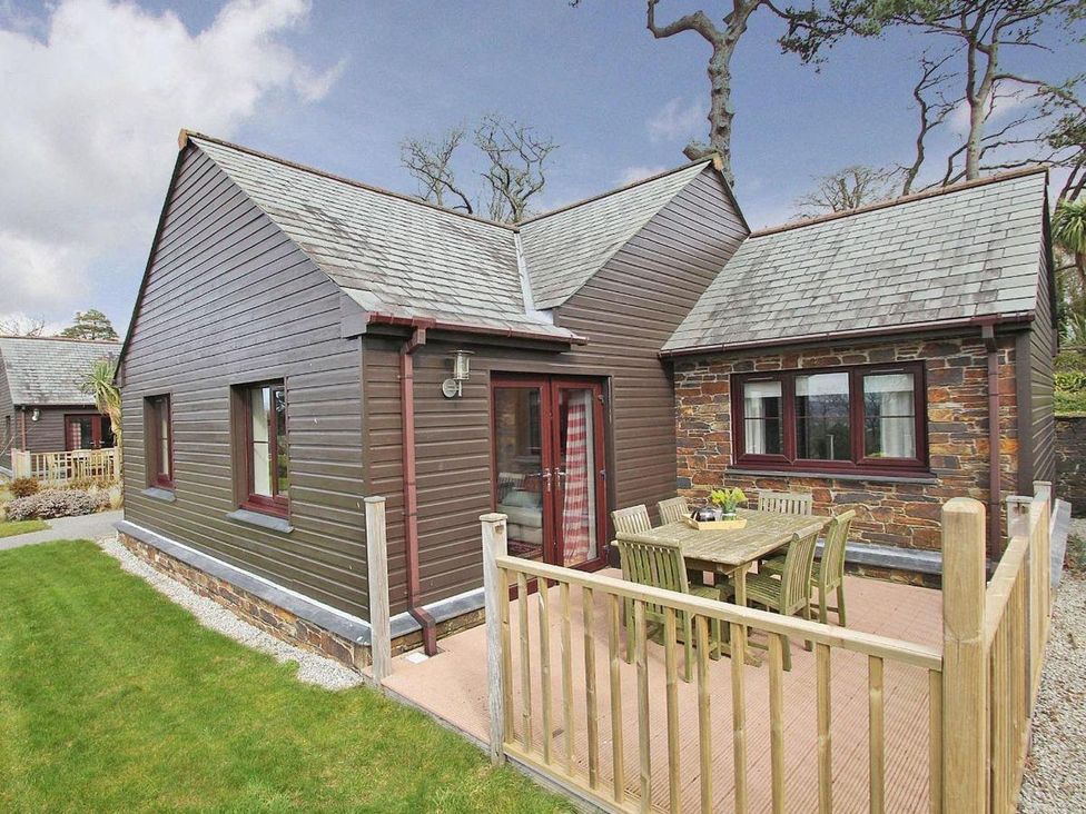 A house with a deck and table outside at 2bed sleeps4 pool freeparking Trenythonestate Near Par