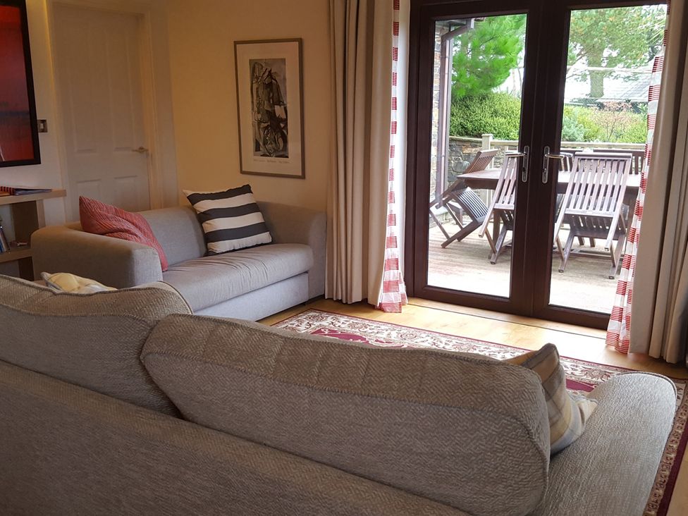 A living room with a sofa and door to the outside at 2bed sleeps4 pool freeparking Trenythonestate Near Par
