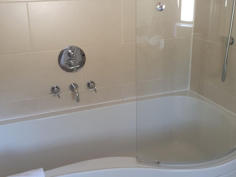 A bath with a shower and faucet at 2bed sleeps4 pool freeparking Trenythonestate Near Par