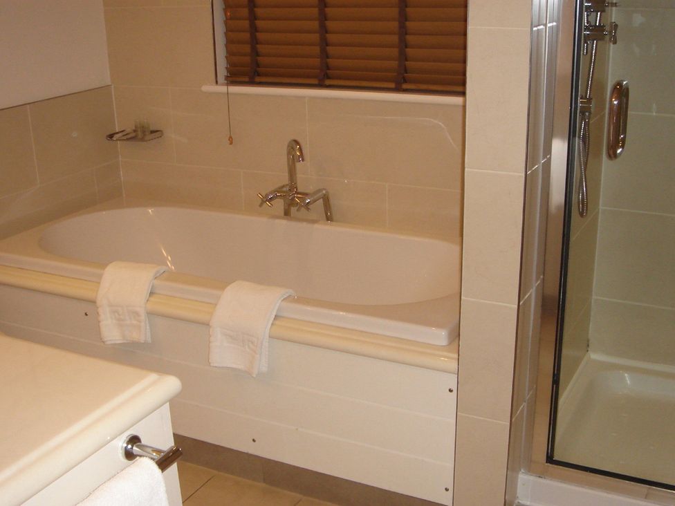 A bathroom with a bathtub and shower at 2bed sleeps4 pool freeparking Trenythonestate Near Par