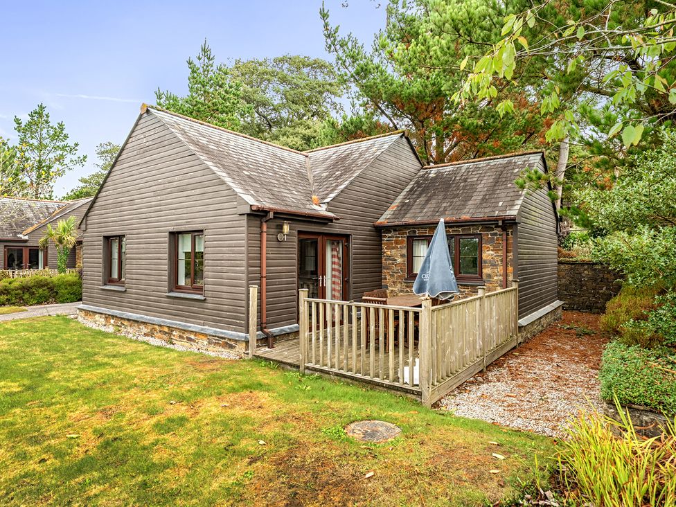 A brown house with a deck and umbrella at 2bed sleeps4 pool freeparking Trenythonestate Near Par