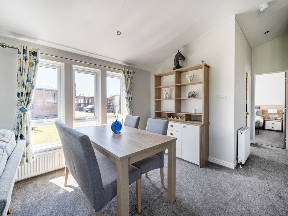A dining room with a table and chairs at Atlantic Breeze Luxury Lodge sleep 6 Mullacott near Ilfracombe
