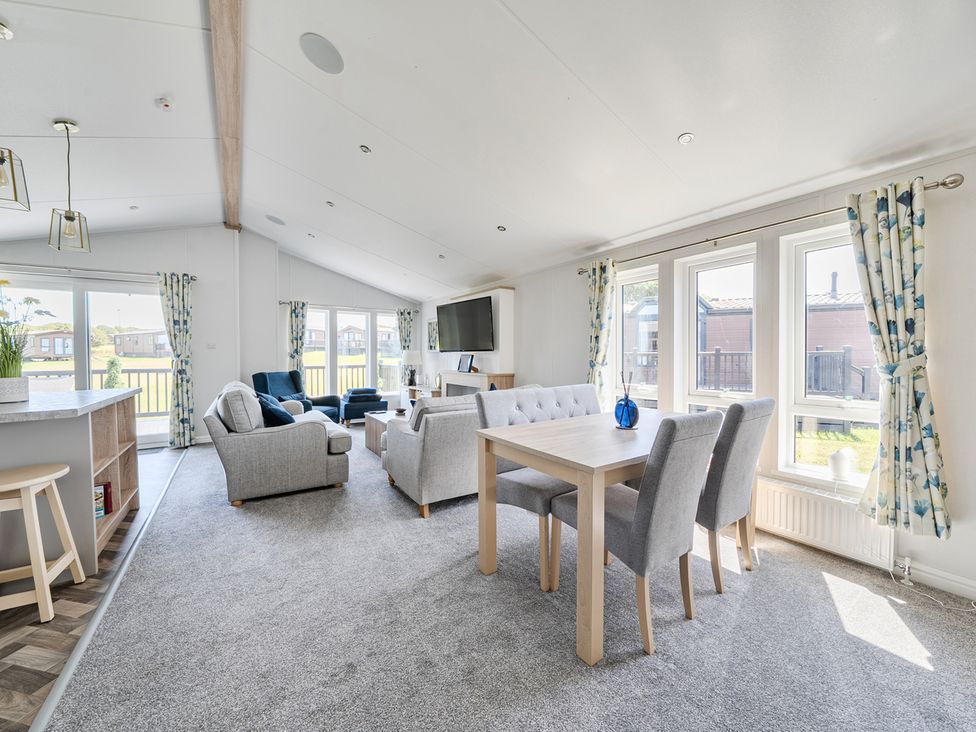 A living room with a sofa, armchair, and dining table at Atlantic Breeze Luxury Lodge sleep 6 Mullacott near Ilfracombe
