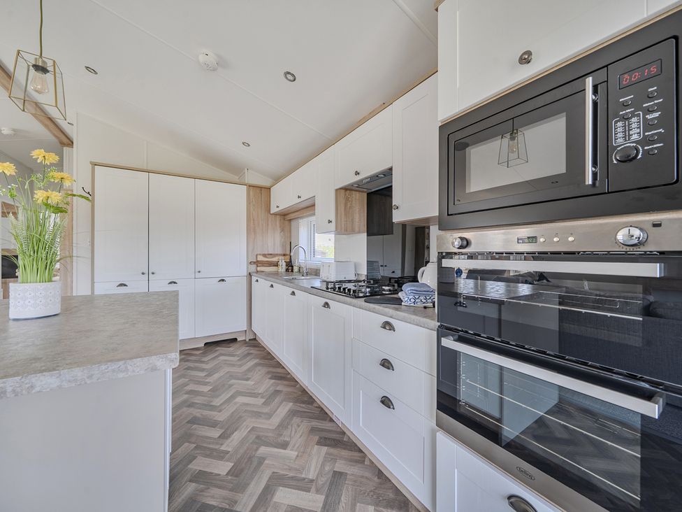 A kitchen with cabinets and appliances at Atlantic Breeze Luxury Lodge sleep 6 Mullacott near Ilfracombe