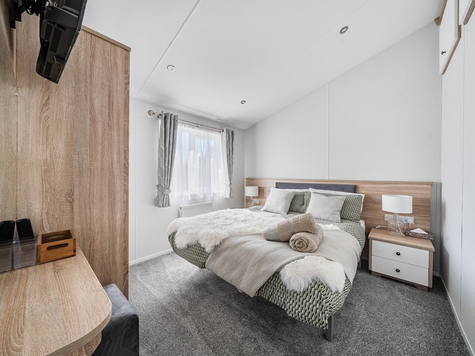 A bedroom with a bed and bedside table at Atlantic Breeze Luxury Lodge sleep 6 Mullacott near Ilfracombe