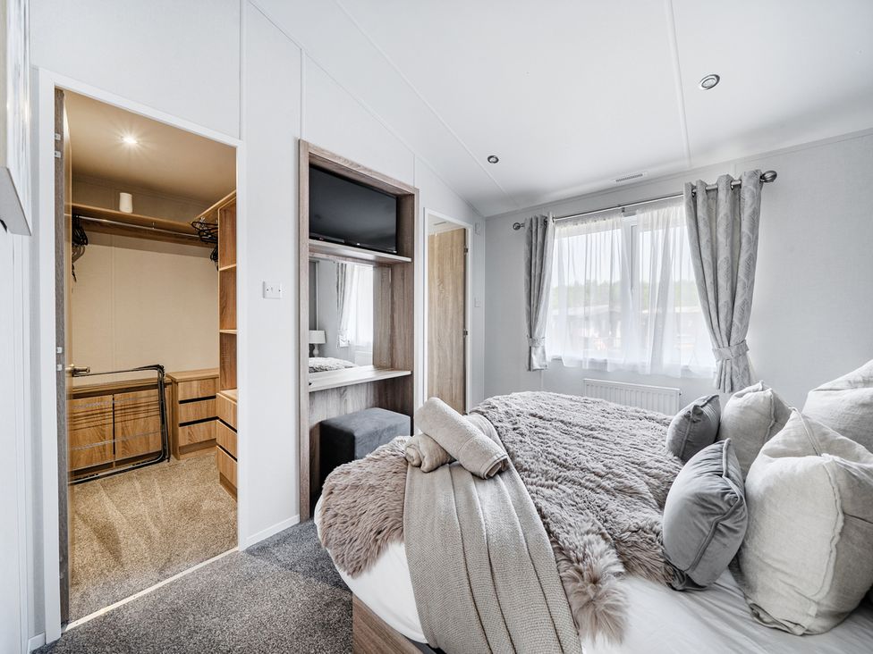 A bedroom with a bed and a closet at Atlantic Breeze Luxury Lodge sleep 6 Mullacott near Ilfracombe