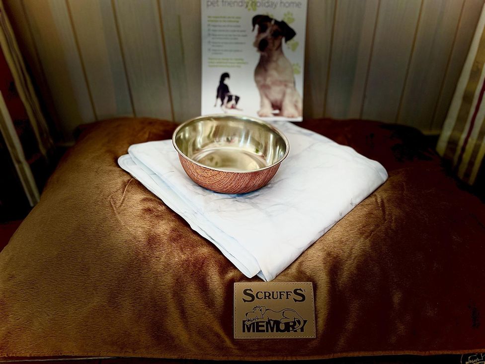 A pet area with a bed, bowl, blanket, and information sheet at Stunning Sleeps 6 Luxury Lodge Pets Mercia Marina near Willington, Derbyshire