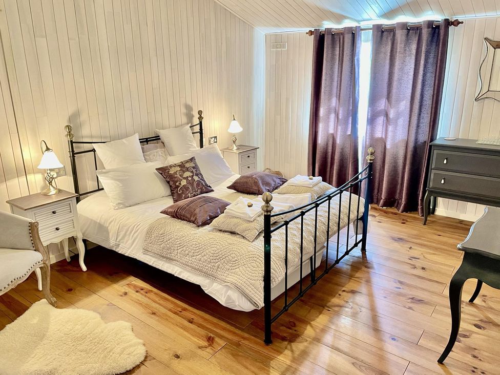 A bedroom with a bed and nightstands at Stunning Sleeps 6 Luxury Lodge Pets Mercia Marina near Willington, Derbyshire