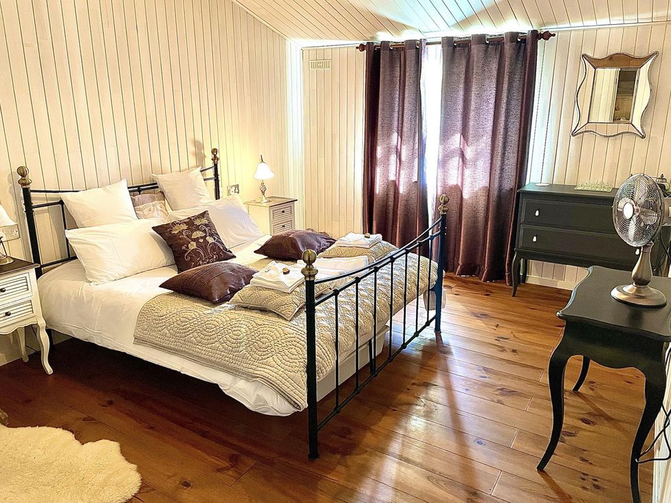 A bedroom with a bed and nightstand at Stunning Sleeps 6 Luxury Lodge Pets Mercia Marina near Willington, Derbyshire