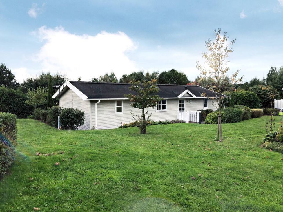A house with a lawn and trees at Stunning Sleeps 6 Luxury Lodge Pets Mercia Marina near Willington, Derbyshire