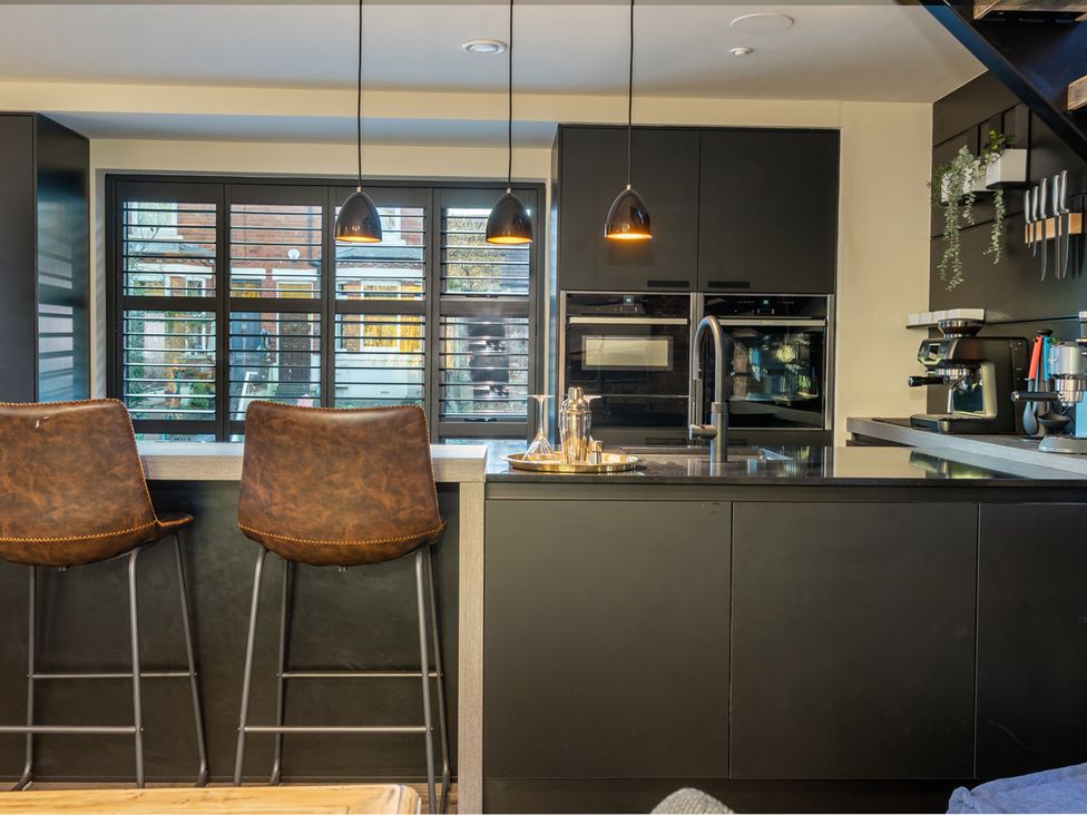 A kitchen with bar stools and appliances at 