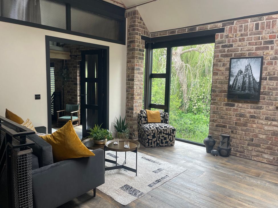 A living room with a sofa, coffee table, and green view at the property in 