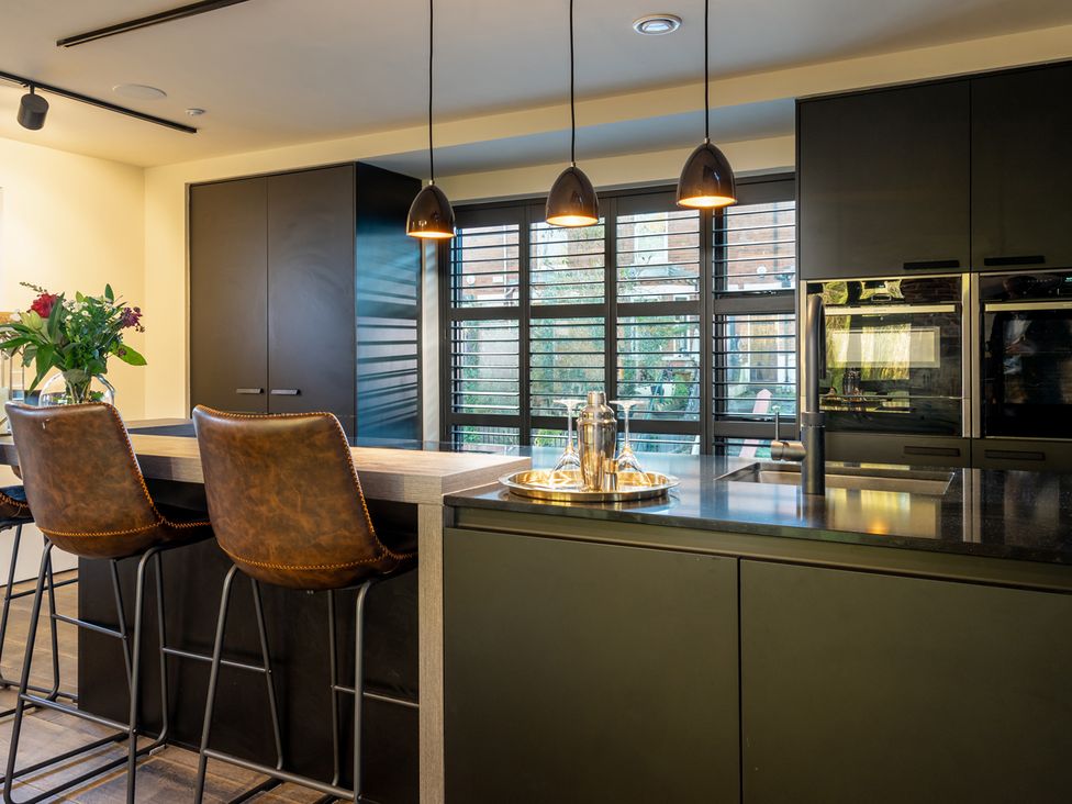 A kitchen with a central island and bar stools at the property in 