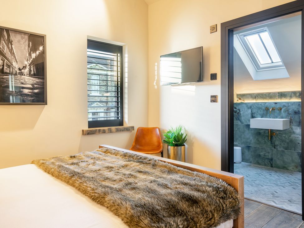 A bedroom with a bed and television at The Old Barn in Manchester