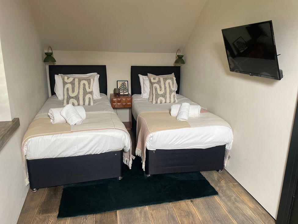 A bedroom with twin beds and a television