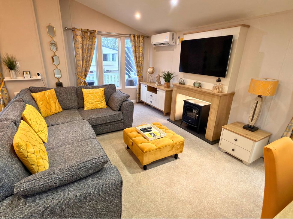 A living room with a sofa and television at Meadows 33 Hot tub Southview Holiday Park Skegness