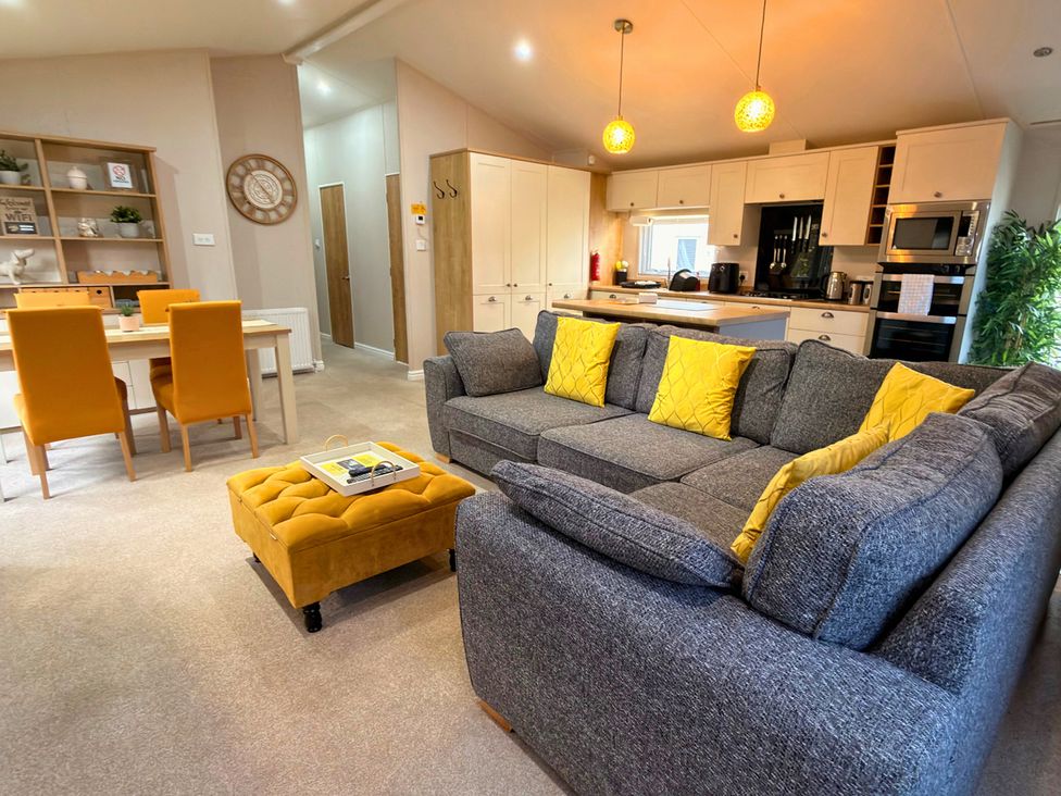 A living room with a sofa and dining table at Meadows 33 Hot tub Southview Holiday Park Skegness