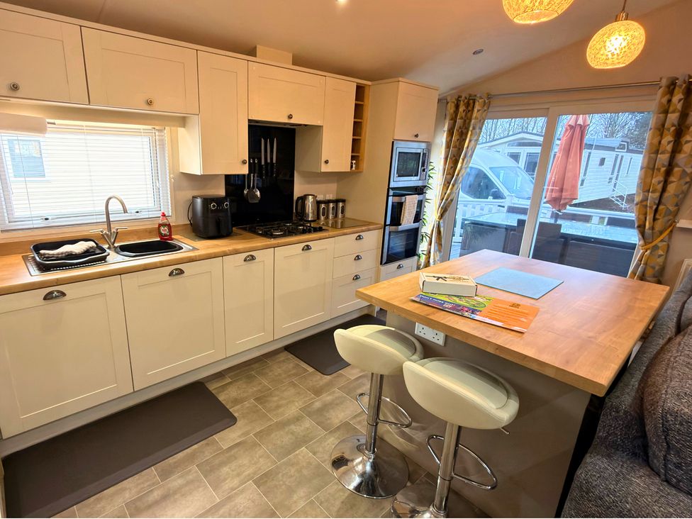 A kitchen with a sink and stove at Meadows 33 Hot tub Southview Holiday Park Skegness