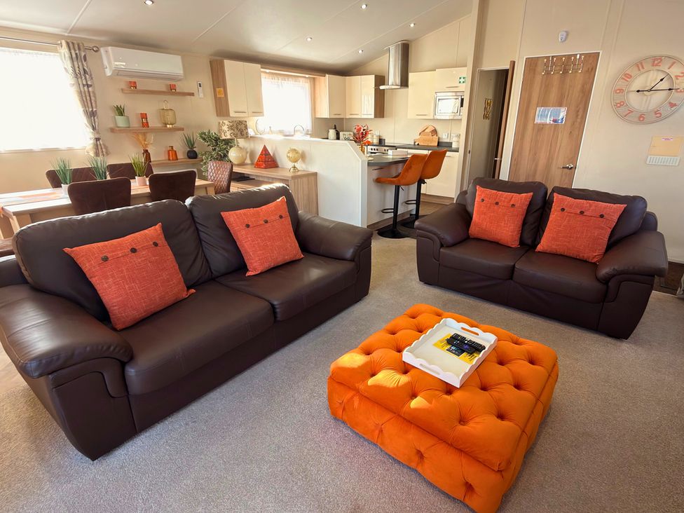 A living room with sofas and a dining area at Sunset 19 Southview Holiday Park Skegness