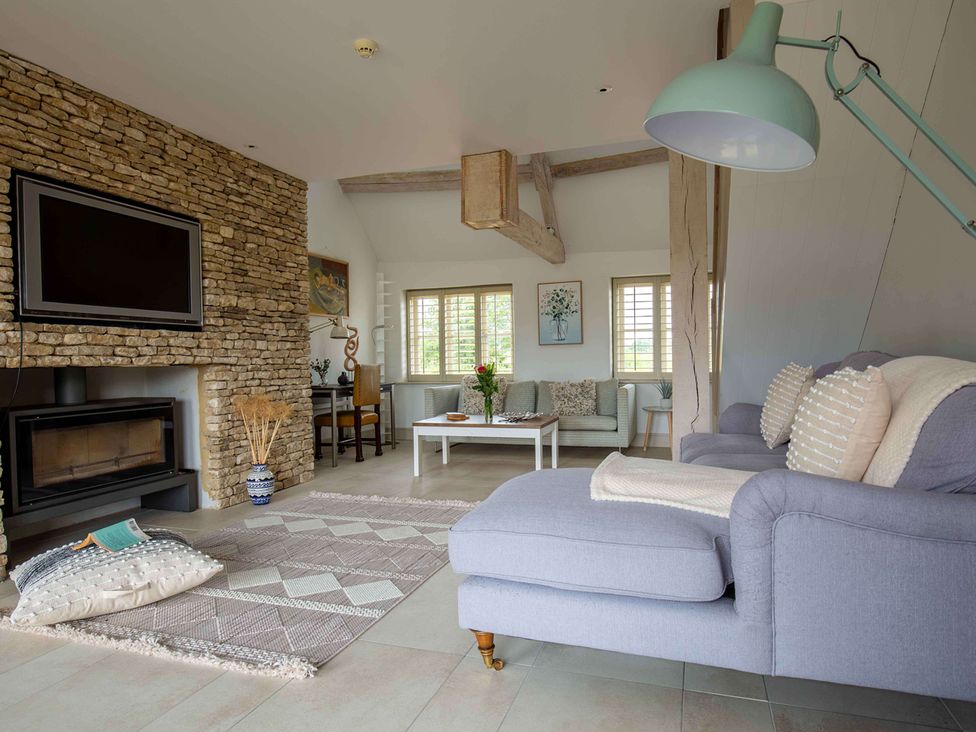 A living room with a sofa and coffee table at Stunning 6 Bedroom Riverside Barn Cotswold Mill Ewan near Kemble