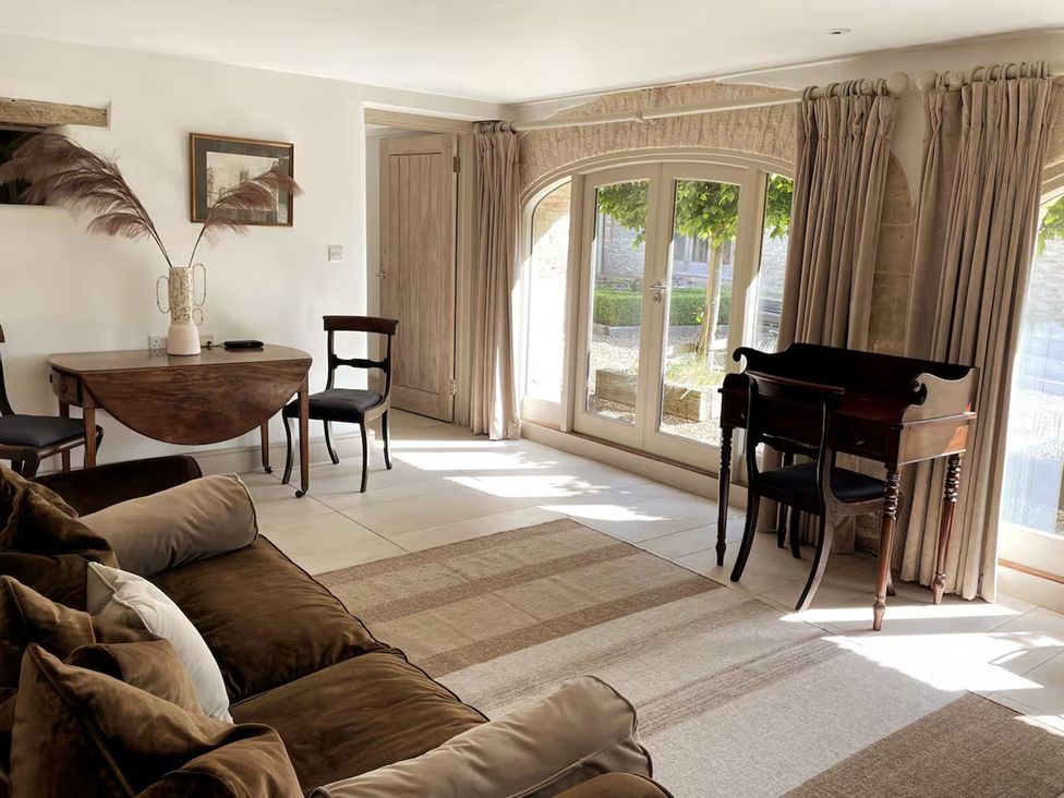 A living room with a table and chairs at Stunning 6 Bedroom Riverside Barn Cotswold Mill Ewan near Kemble