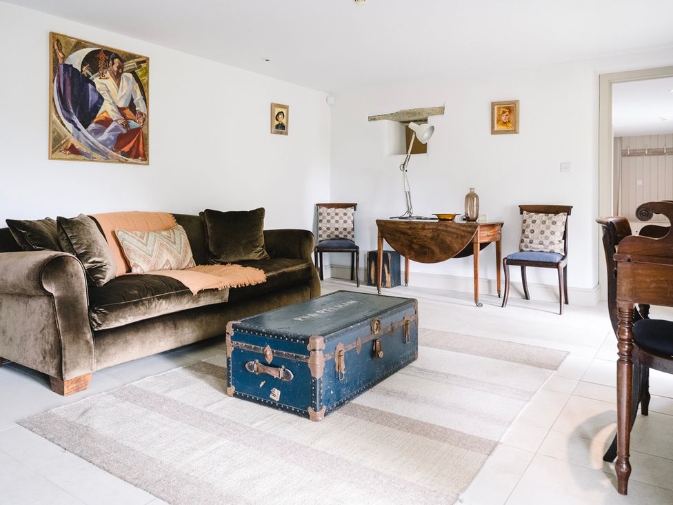 A living room with a sofa and trunk at Stunning 6 Bedroom Riverside Barn Cotswold Mill Ewan near Kemble