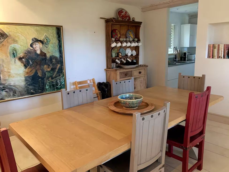 A dining room with a table and chairs at Stunning 6 Bedroom Riverside Barn Cotswold Mill Ewan near Kemble
