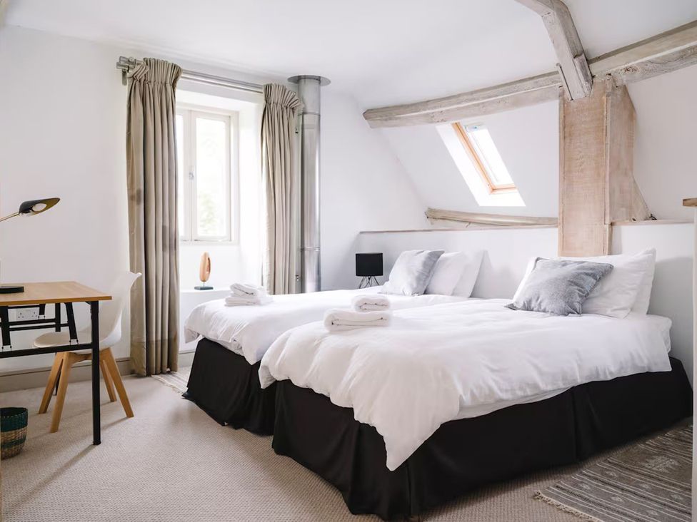 A bedroom with two beds and a desk at Stunning 6 Bedroom Riverside Barn Cotswold Mill, Ewan near Kemble
