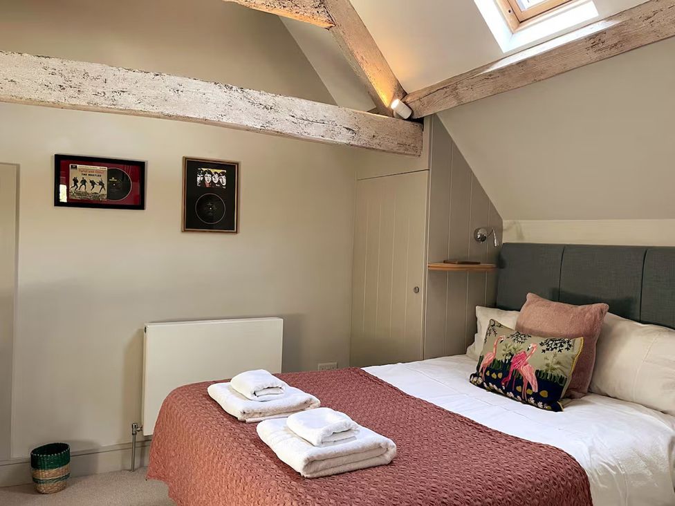 A bedroom with a bed and wall art at Stunning 6 Bedroom Riverside Barn Cotswold Mill Ewan near Kemble