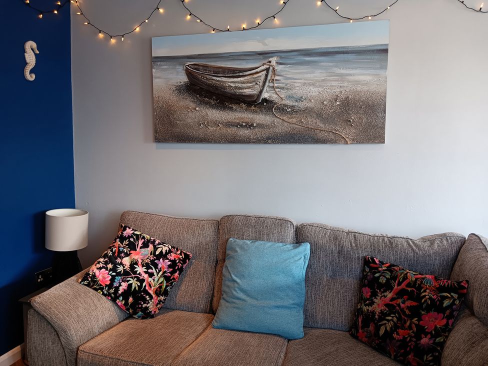 A living room with a sofa and wall art at Seahorse Chalet Sleeps 6 Pets Log Burner Beach in Bridlington
