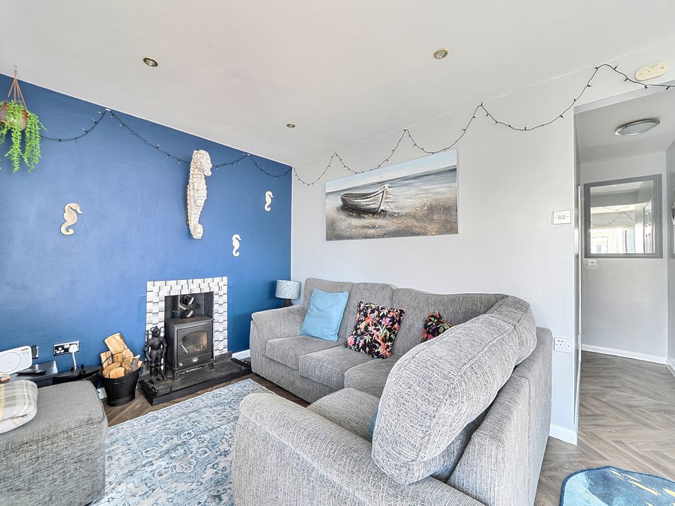 A living room with a sofa and fireplace at Seahorse Chalet Sleeps 6 Pets Log Burner Beach in Bridlington