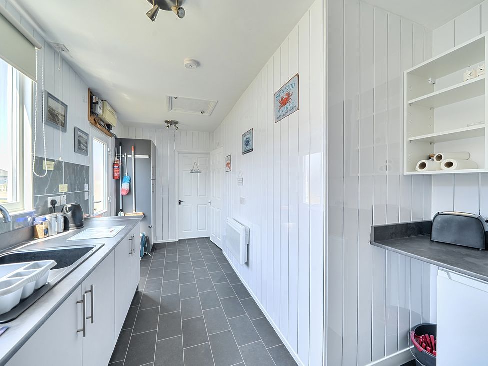 A kitchen with sink and refrigerator at Seahorse Chalet Sleeps 6 Pets Log Burner Beach in Bridlington