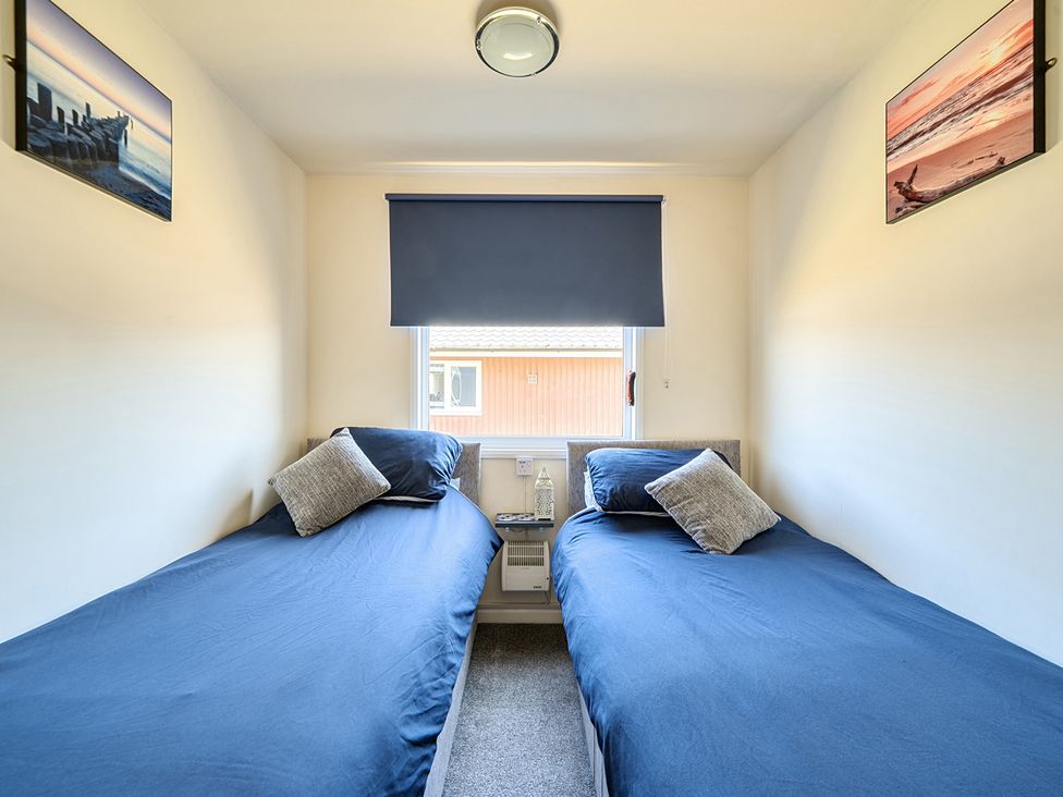 A bedroom with two single beds and wall art at Seahorse Chalet Sleeps 6 Pets Log Burner Beach in Bridlington